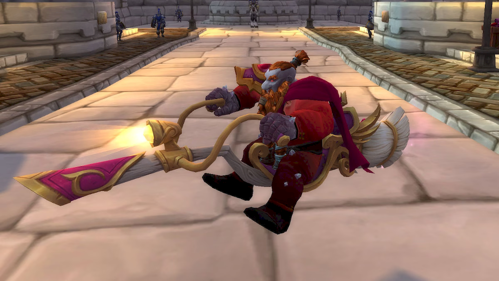 A male dark iron dwarf in red garb riding the Love Witch’s Sweeper. This broom mount has pink & gold detailing and seat over a broomstick made of white wood and with a white brush. It has golden handlebars with a headlight in the middle and a purple plush seat - it’s something like a motorbike version of a broomstick.